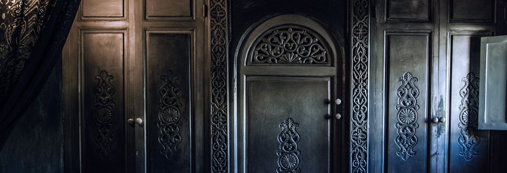 An ornately carved black set of doors