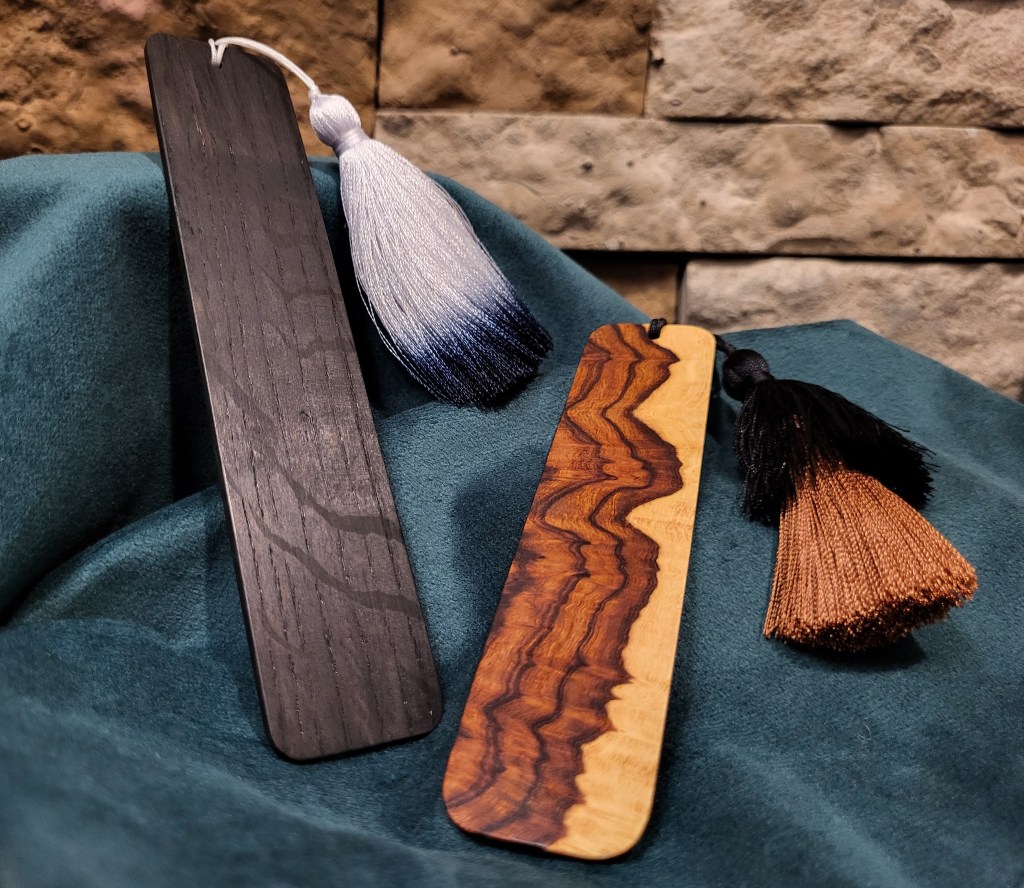 A pair of wooden bookmarks with tassels